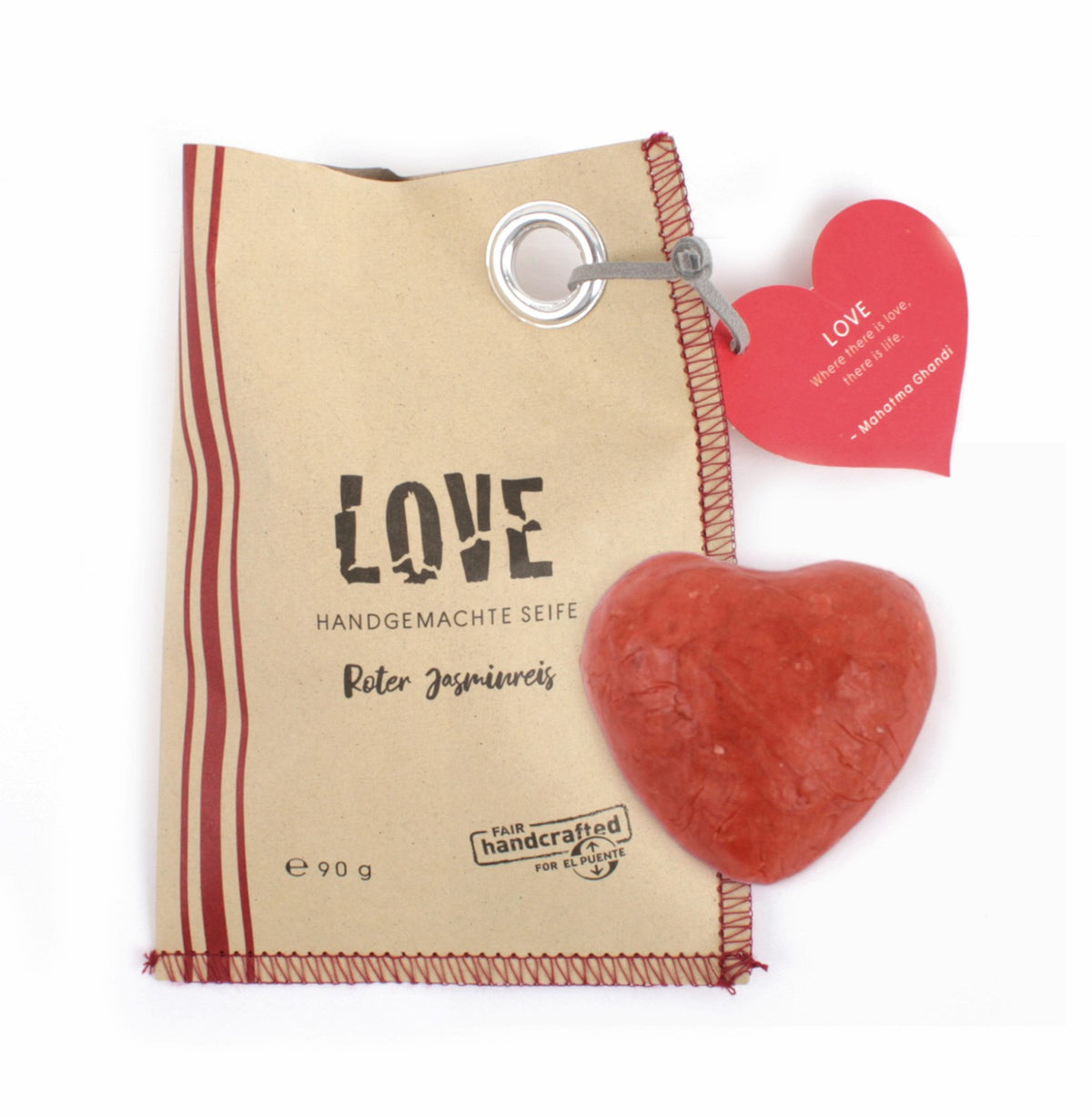 braune Papiertüte, links drei rote Streifen, mittig in Schwarz die Aufschrift "LOVE", oben rechts befindet sich ein roter Papieraufhänger in Herzform, darunter ein Stück rote Seife in Herzform