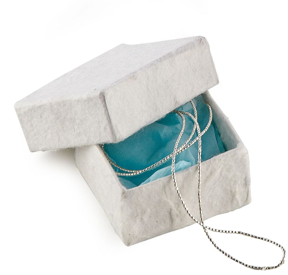 kleine weiße Schachel mit blauem Seidenpapier und einer silbernen Kette im Inneren