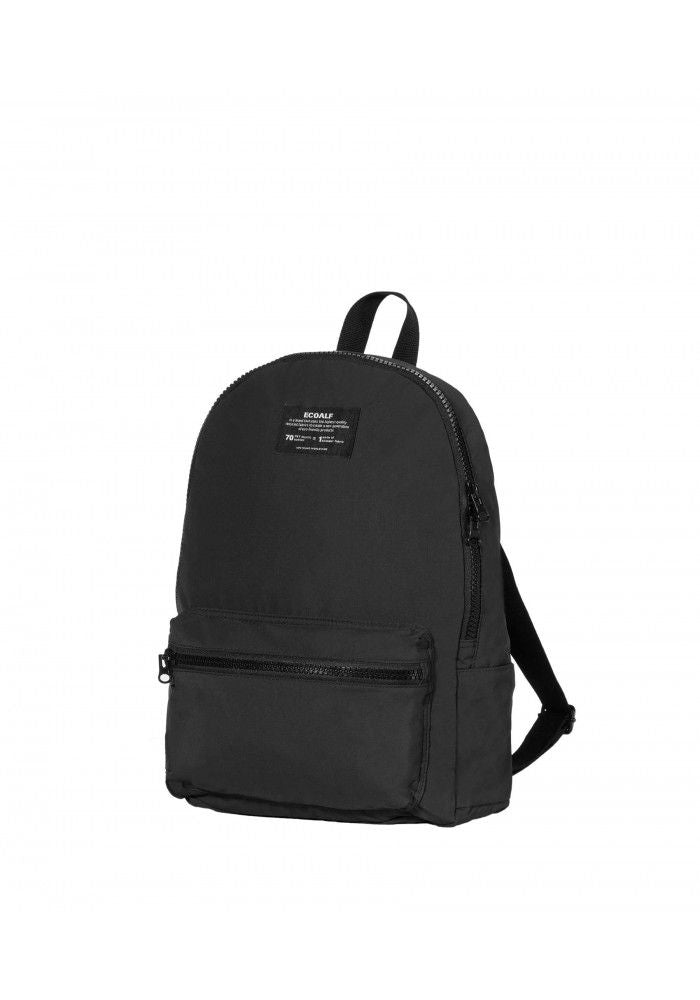 Black backpack, side view. You can see the small manufacturer's label at the top and a compartment with zip at the front