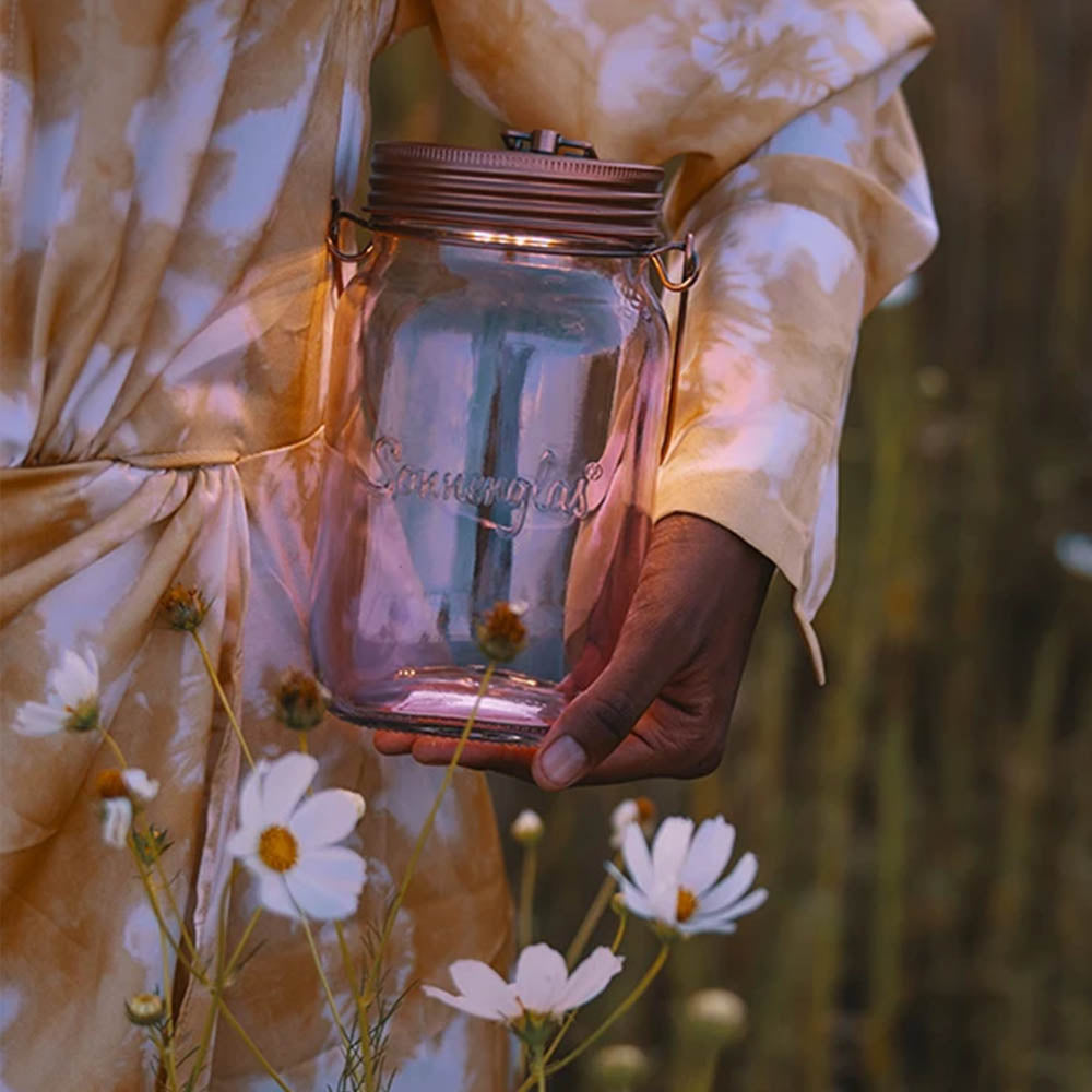 One illuminated sun jar is carried by a person under their arm