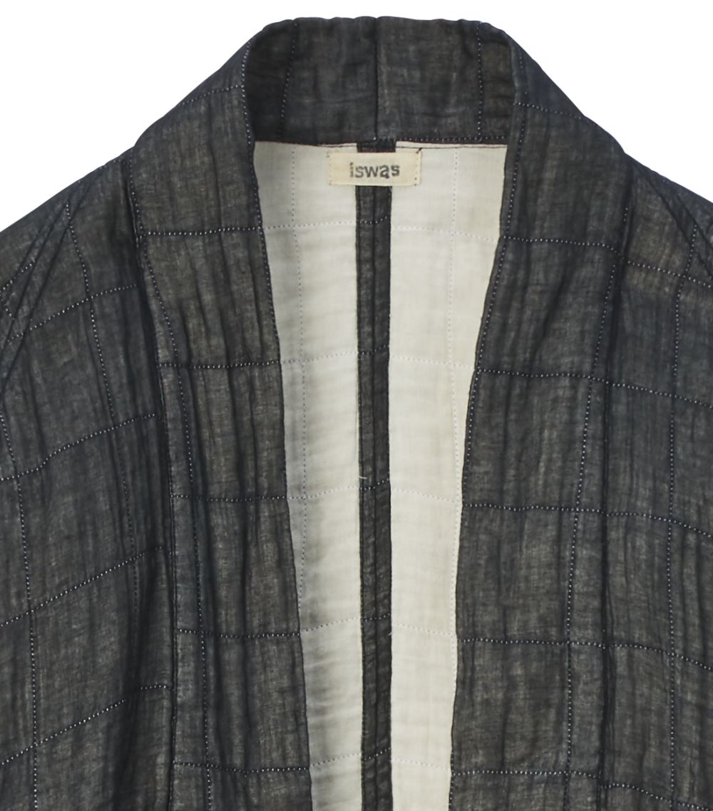 Close-up of the black kimono jacket, you can see the light-coloured inner fabric and the manufacturer's label