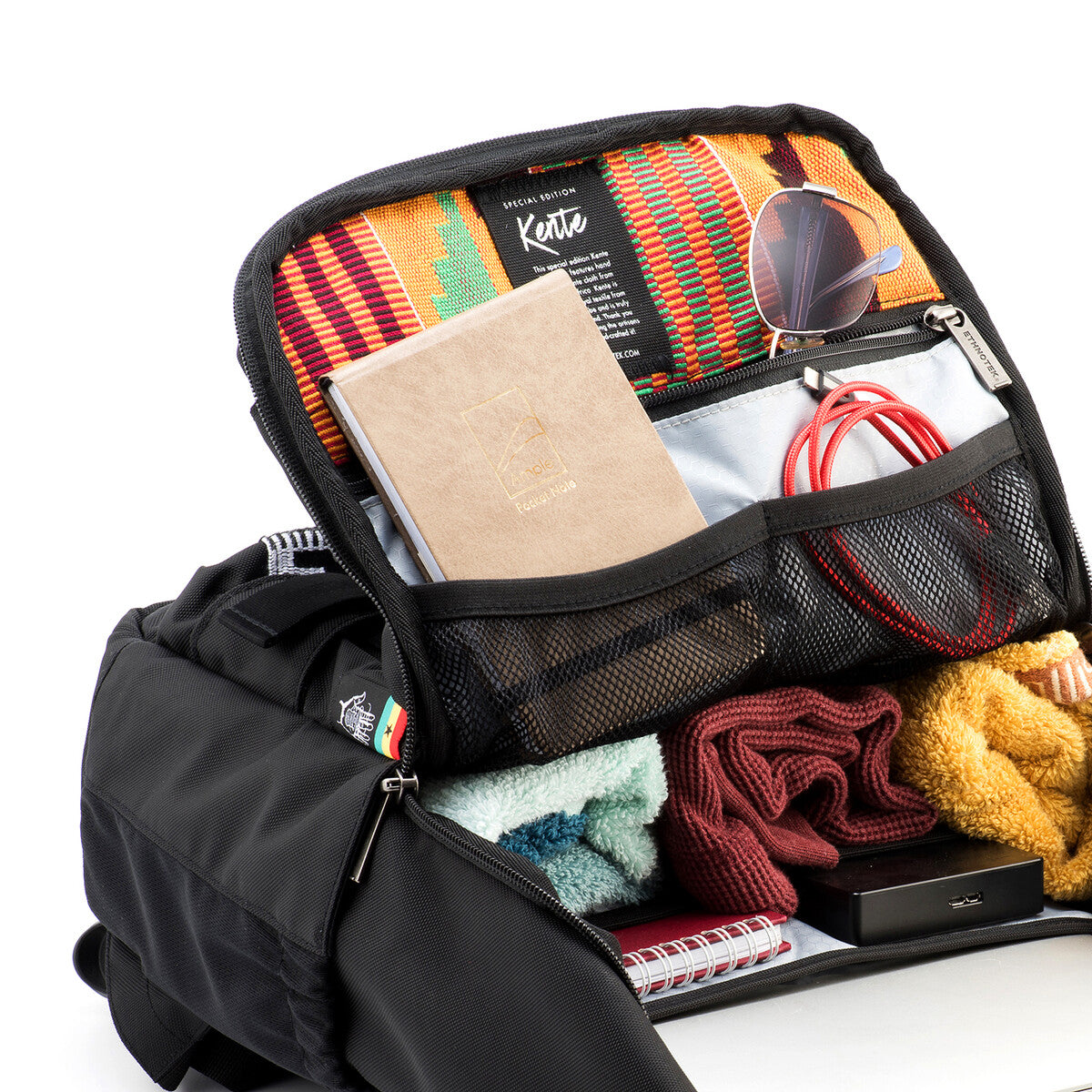 Inner part of a black backpack with several compartments containing various utensils