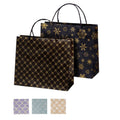 zwei schwarze Papier Geschenktaschen mit unterschiedlichem Muster und Henkeln, darunter sind andere Farbein (lila, türkis und beige) abgebildet