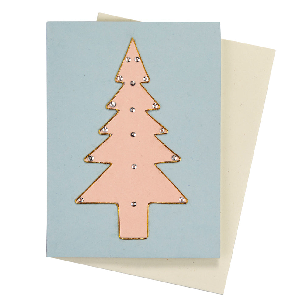 Hellblaue Karte mit rosafarbenen, mit Glitzersteinen verzierten Tannenbaum. Dahinter ein beiger Briefumschlag