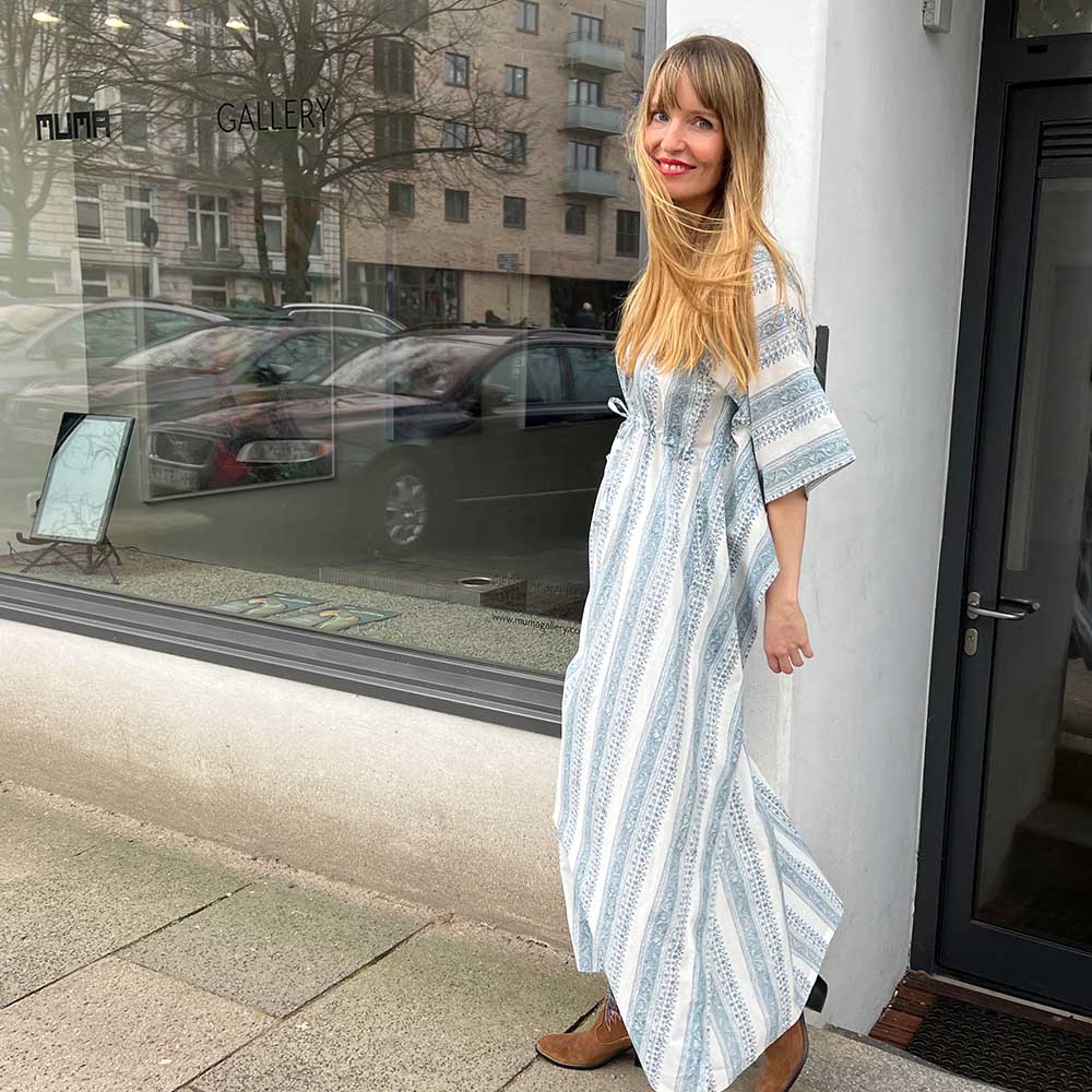 seitliche Ansicht der jungen Frau in dem blau-weiß gestreiften Oversized Sommerkleid