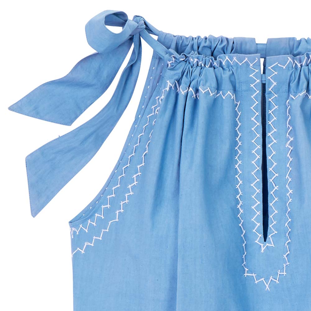 Detail, light blue top. The drawstring neckline is closed with a bow. 