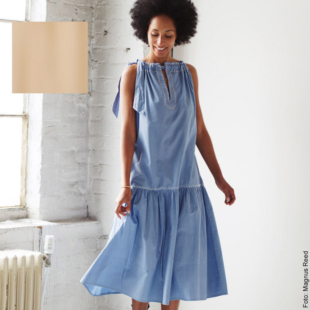 lächelnde Frau in einem hellblauen Neckholder Kleid