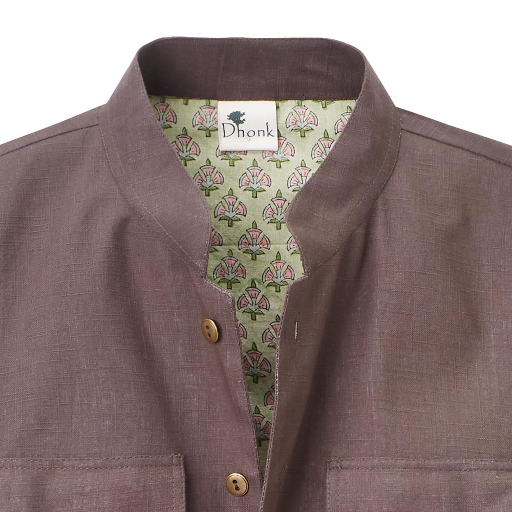 Close-up of the collar of the brown jacket, inside the fabric is light green with pattern
