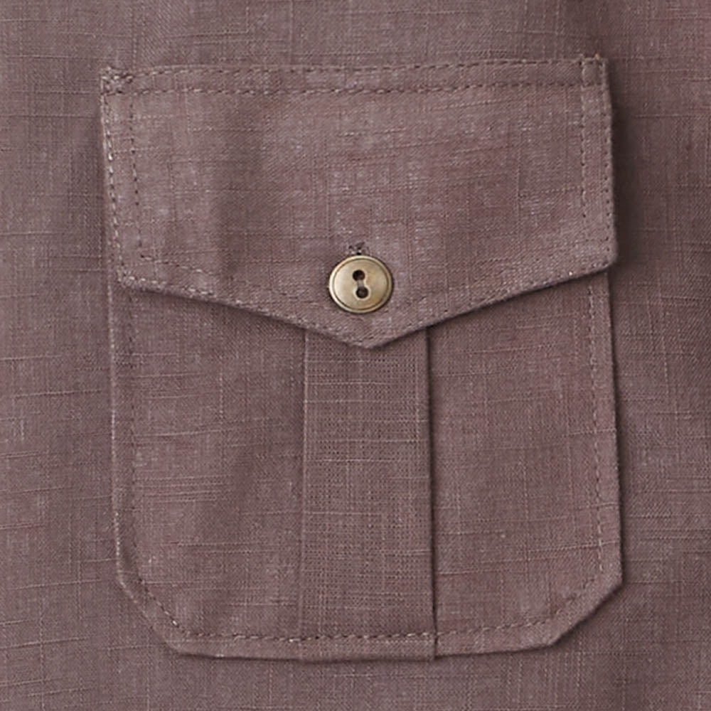 Close-up of a buttoned breast pocket of the brown jacket