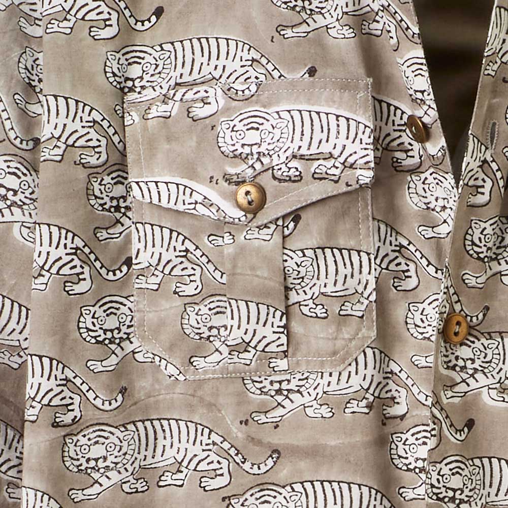 Close-up of a breast pocket of the light grey jacket with tiger print