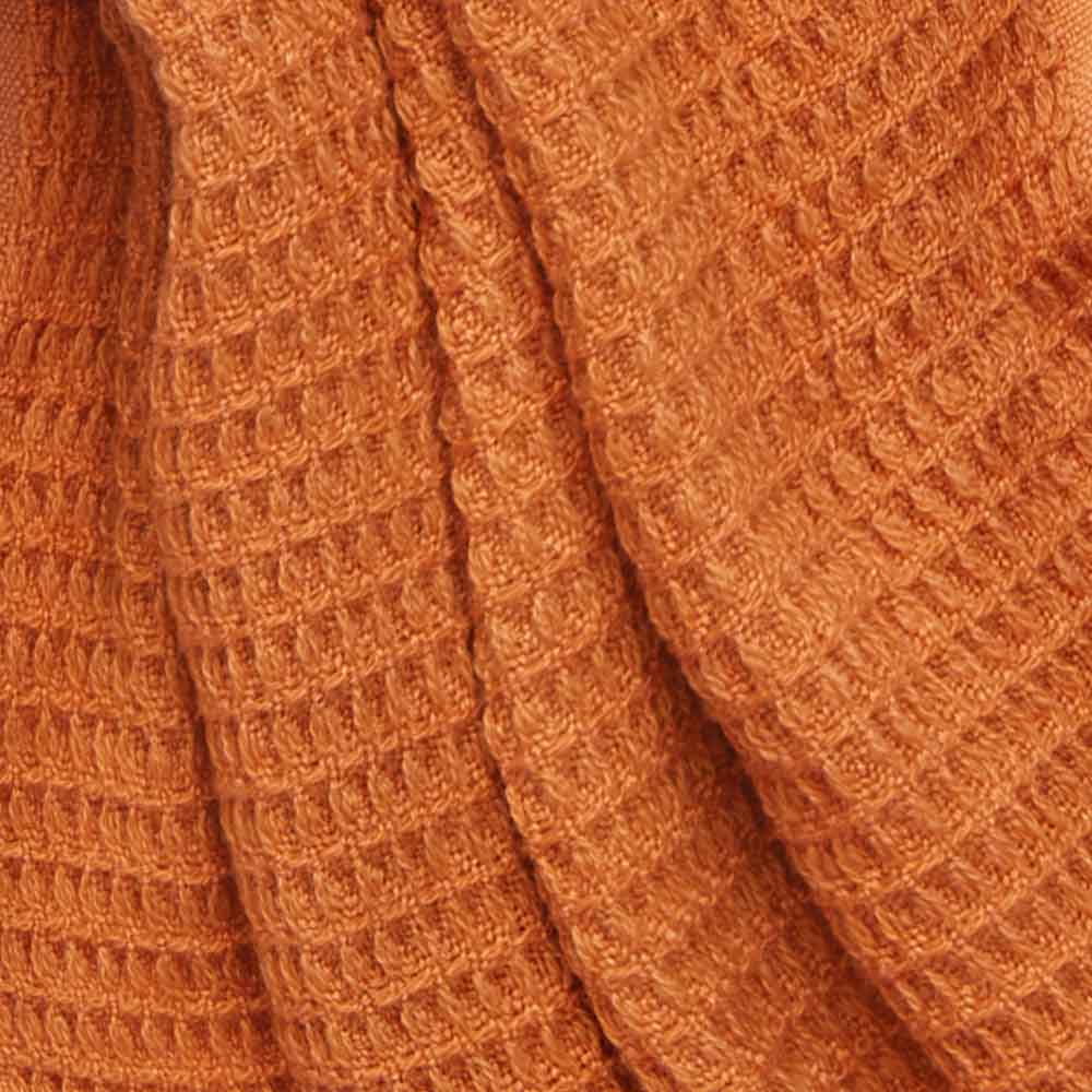 Close-up of the orange-coloured scarf, on which the waffle pattern is clearly visible