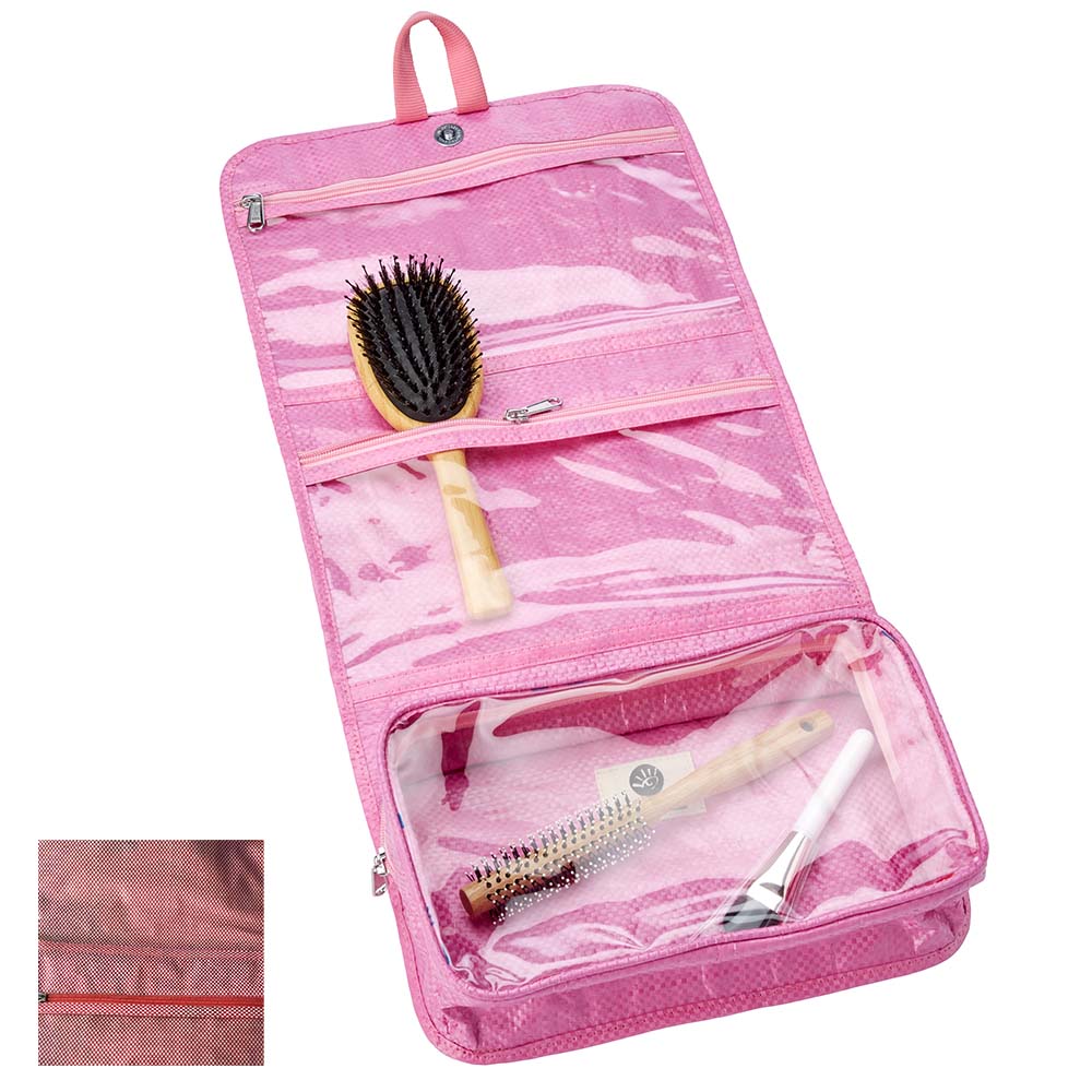 liegende geöffnete rosa Kulturtasche mit drei transparenten Fächern mit Reißverschlüssen, in denen sich Bürsten befinden