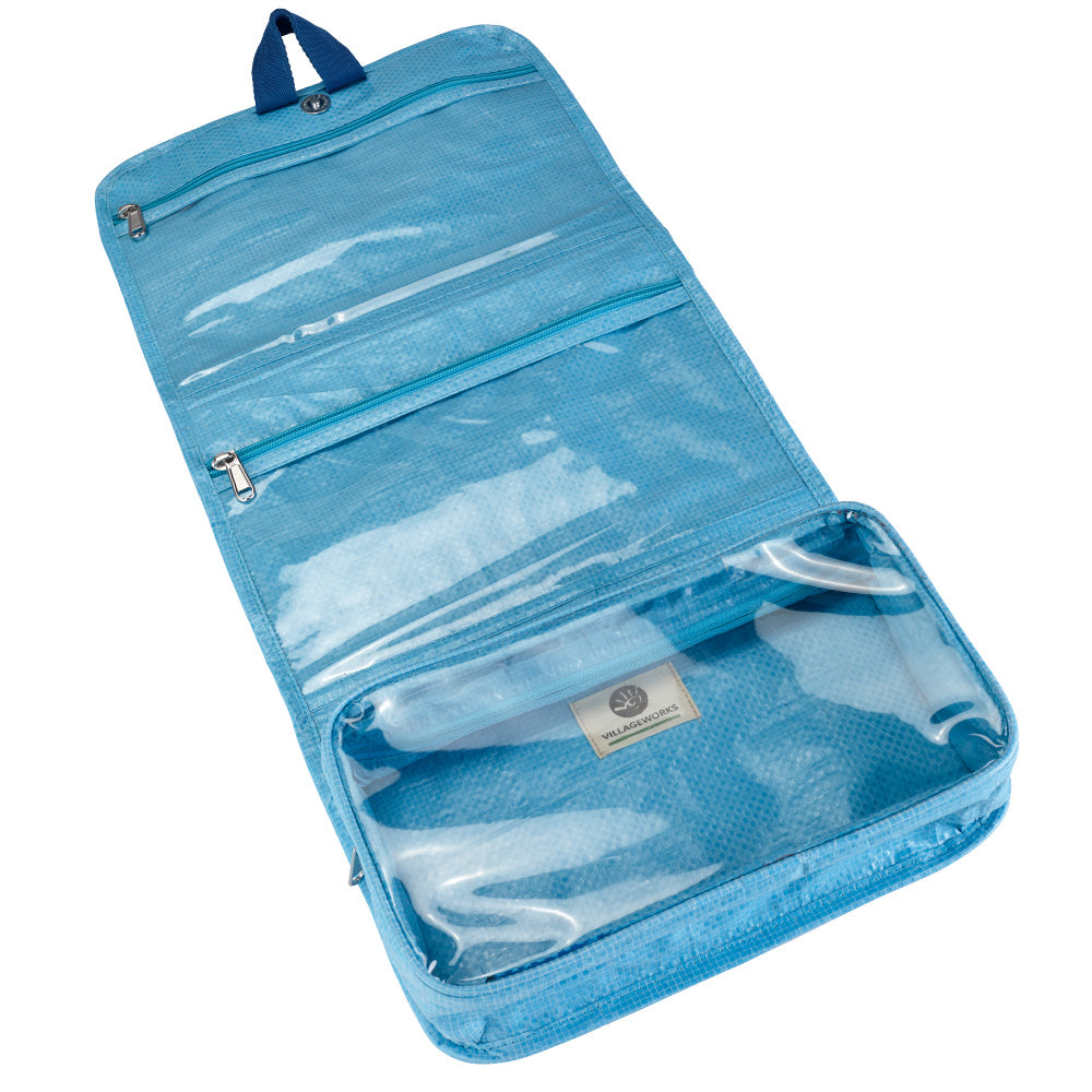 Interior view of the toiletry bag, with 2 shallow zip compartments and one deep compartment. The inner compartments are transparent. 