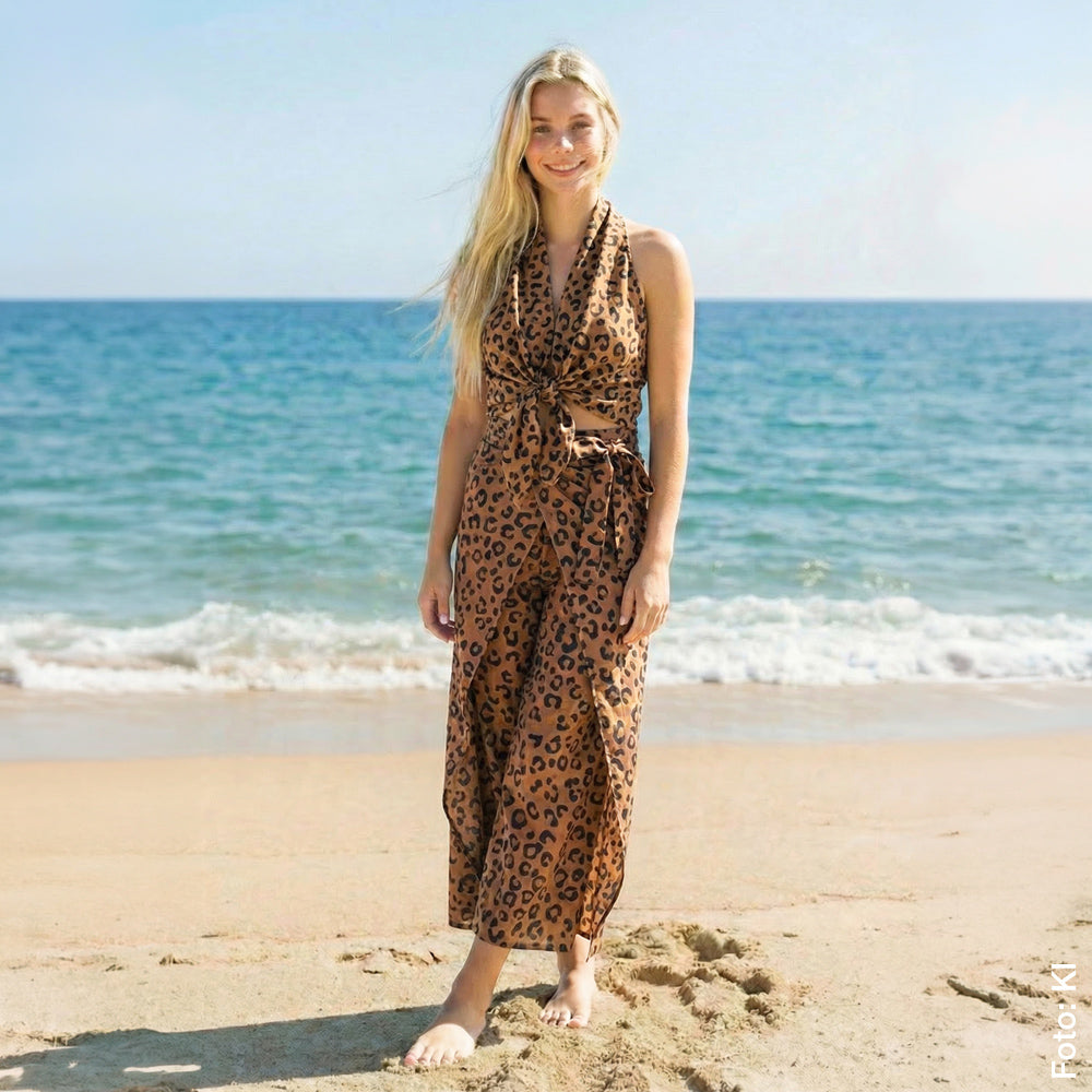 Tragevariante Overall aus zwei Tüchern, am Model gezeigt mit Strand und Meer im Hintergrund.