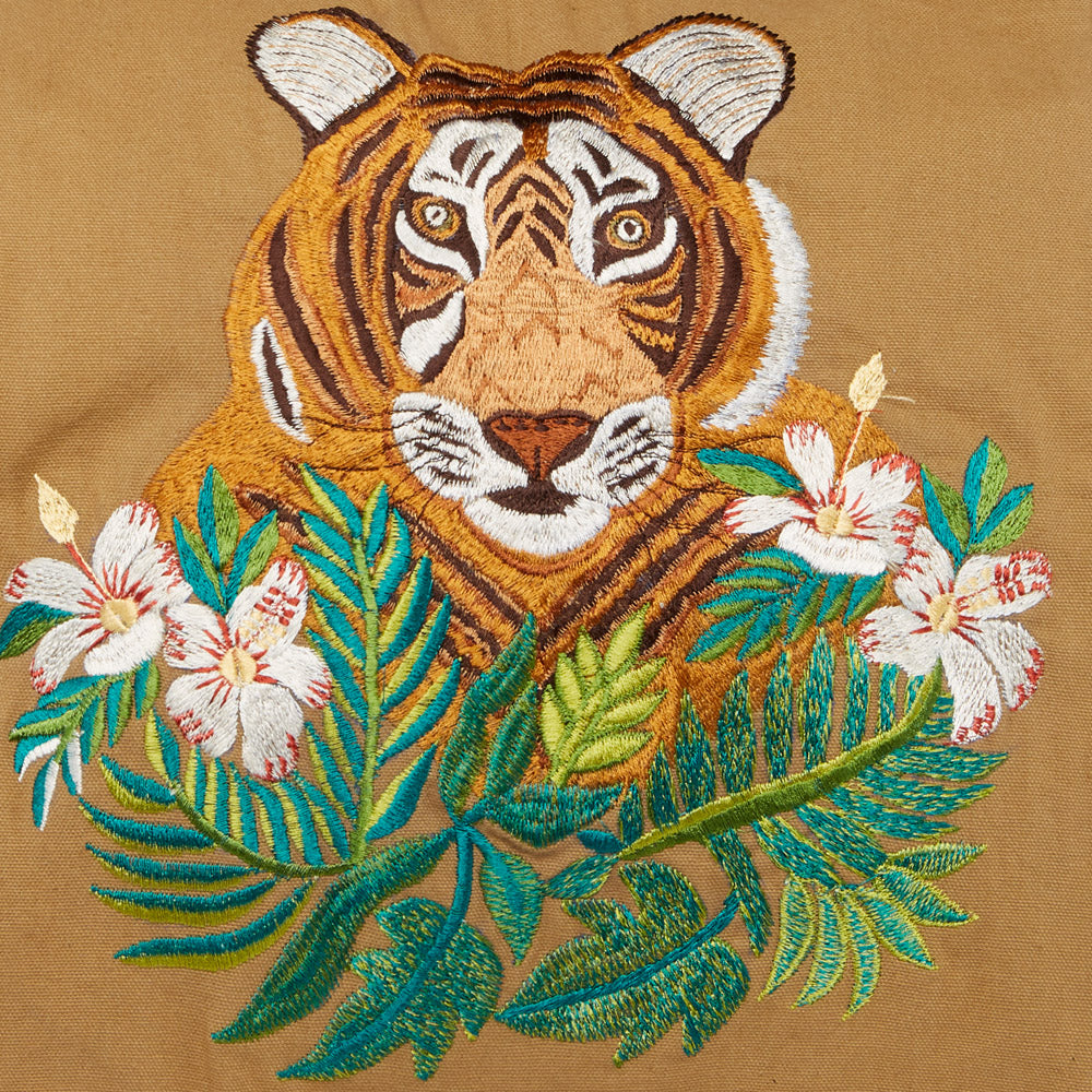 gesticktter Tigerkopf hinter gestickten exotischen Blumen auf braunem Stoff