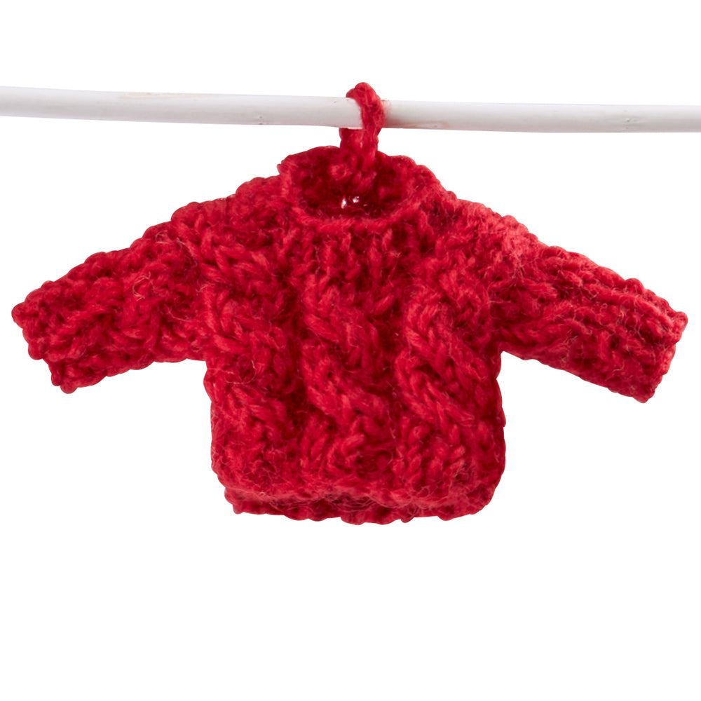 Anhänger in Form eines kleinem Pullovers an einem Ast hängend.