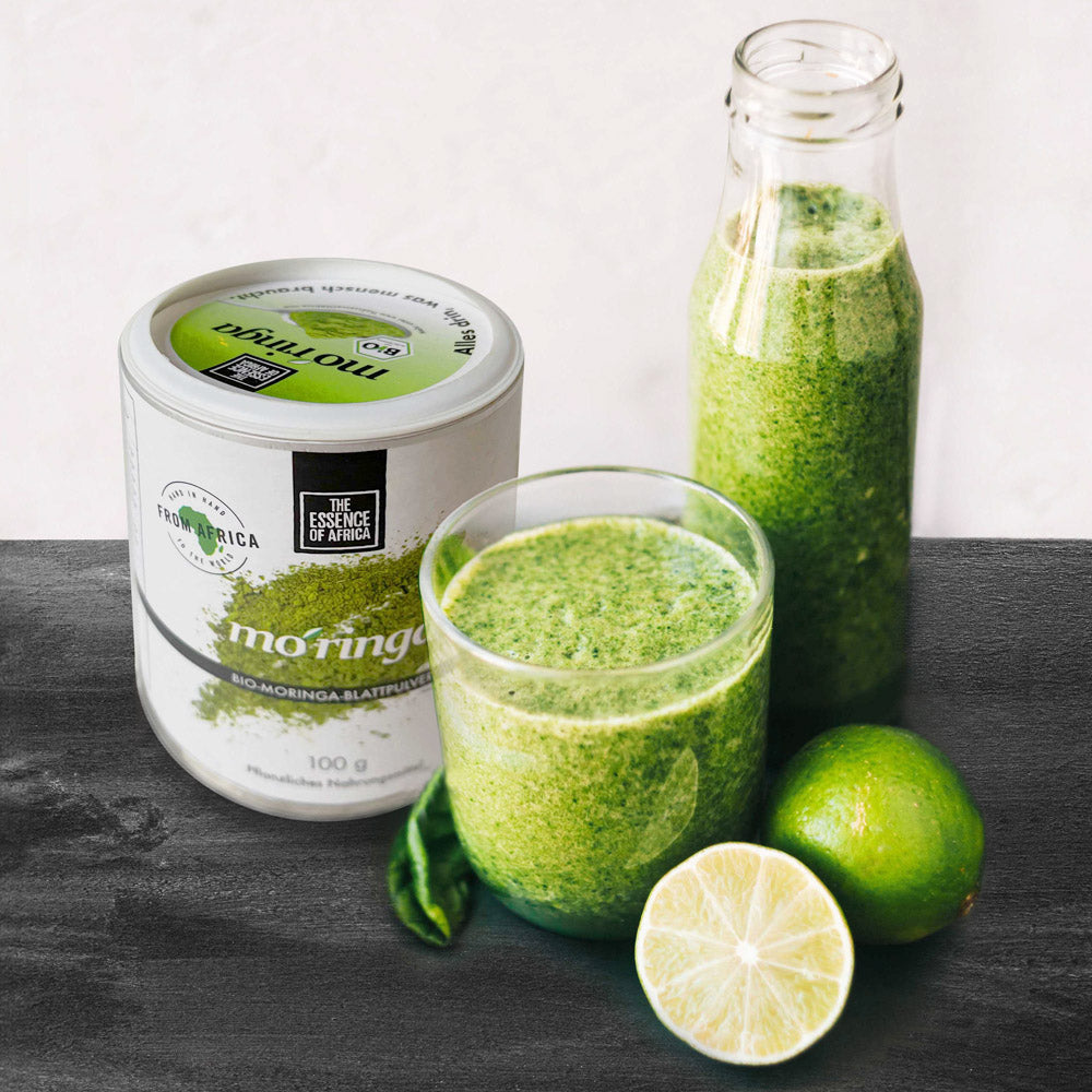 Moringa leaf powder with bottle and glass with Moringa smoothie, in front is a halved lemons and a whole one. The photo is from Alina Karpenko/ Unsplash