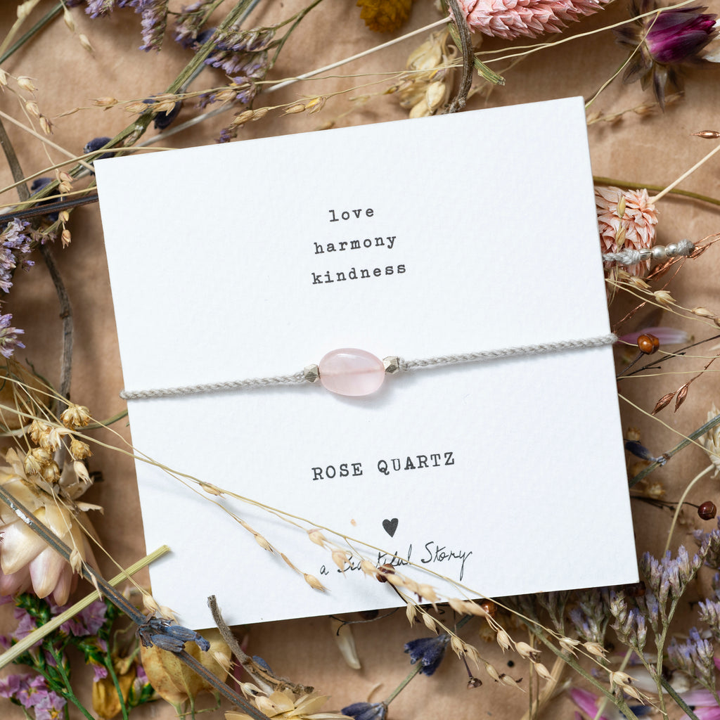 Mood picture: Greeting card with bracelet on a background consisting of dried flowers on wrapping paper.