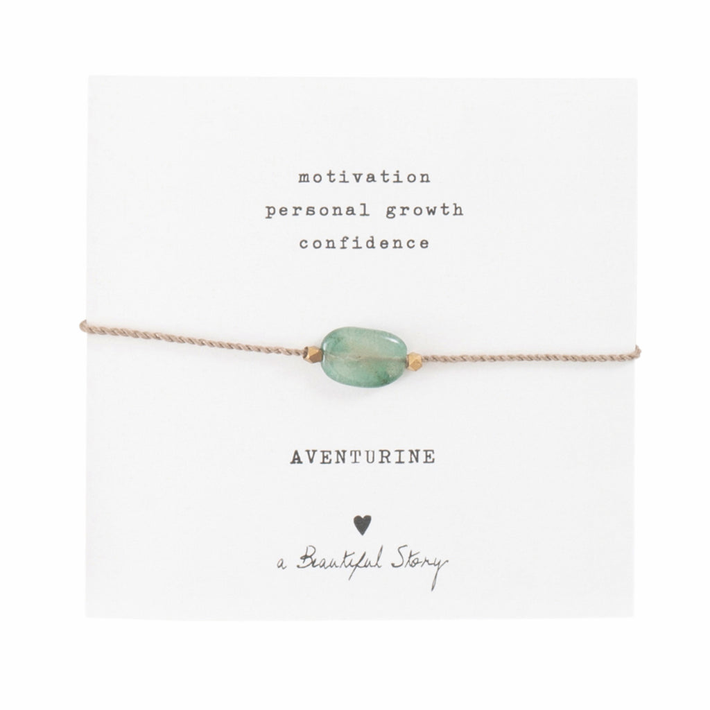 Armband aus goldfarbender Kordel mit grünem Edelstein Aventurin auf Karte, darüber steht "Motivation, personal growth" und "confidence". Darunter der Name des Steins: Aventurine, ein Herzchen und "A Beautiful Story"