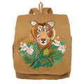 brauner Rucksack mit einem gestickten Tigerkopf. der sich hinter exotischen Blumen befindet