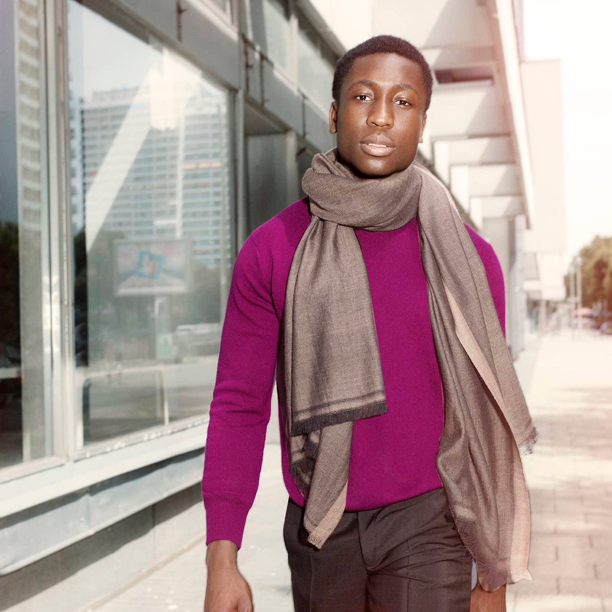 Young man with purple jumper wears brown scarf