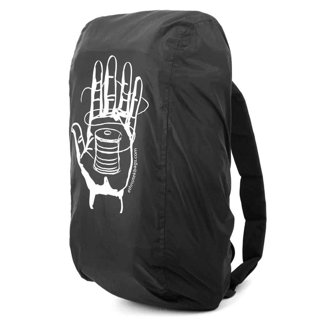 Side view of a backpack over which a black rain cover with the motif of a white hand with a roll of yarn is stretched