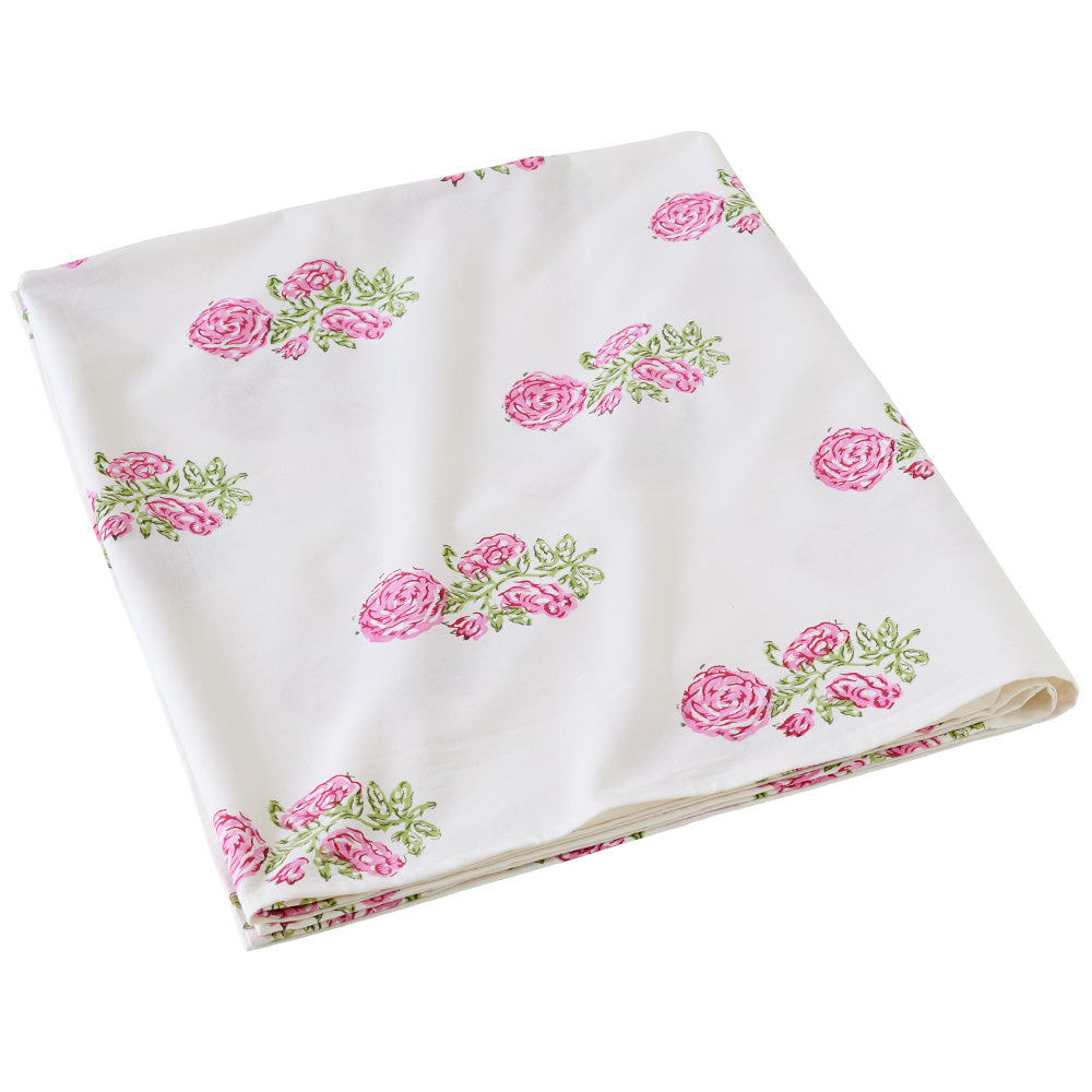Folded white tablecloth with pink rose print.