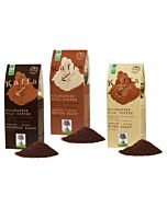 drei Papier Kaffeetüten in dunkelbraun, hellbraun und beige, jeweil mit Aufschrift der Kaffeesorte, davor liegen drei Häufchen gemahlener Kaffee