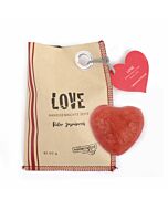 braune Papiertüte, links drei rote Streifen, mittig in Schwarz die Aufschrift "LOVE", oben rechts befindet sich ein roter Papieraufhänger in Herzform, darunter ein Stück rote Seife in Herzform