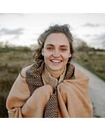 lächelnde junge Frau mit großem beige-schwarzem Schal