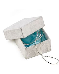 weiße kleine Schachtel mit blauem Seidenpapier und einer silbernen Kette im Inneren