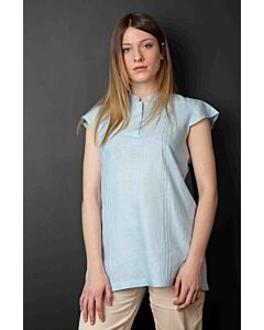 Junge Frau trägt kurzärmelige hellblaue Leinenbluse und beige Cordhose