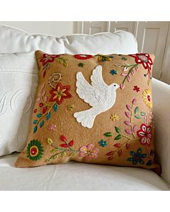 Hellbraunes Kissen mit Stickerei. Die Stickerei zeigt Blumen und Blätter und in der Mitte eine weiße Taube.