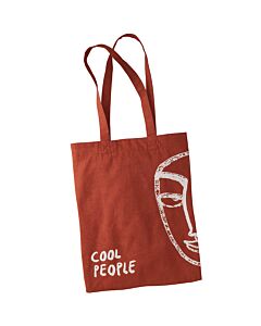 Brown bag with long handles, a cut-out face on the left and lettering on the bottom right.

