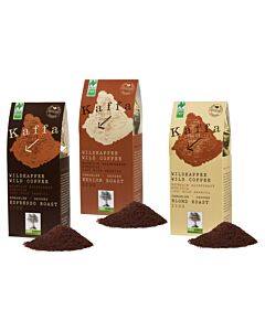 drei Papier Kaffeetüten in dunkelbraun, hellbraun und beige, jeweil mit Aufschrift der Kaffeesorte, davor liegen drei Häufchen gemahlener Kaffee