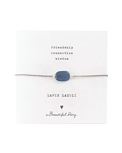 Zartes Armband aus einer silberfarbenden Kordel, mittig ist der blaue Lapislazulistein auf einer kleinen Grußkarte. Oben steht "friendship, connection, wisdom" darunter der Name: Lapis Lazuli, ein Herzchen und "A beautiful Story"